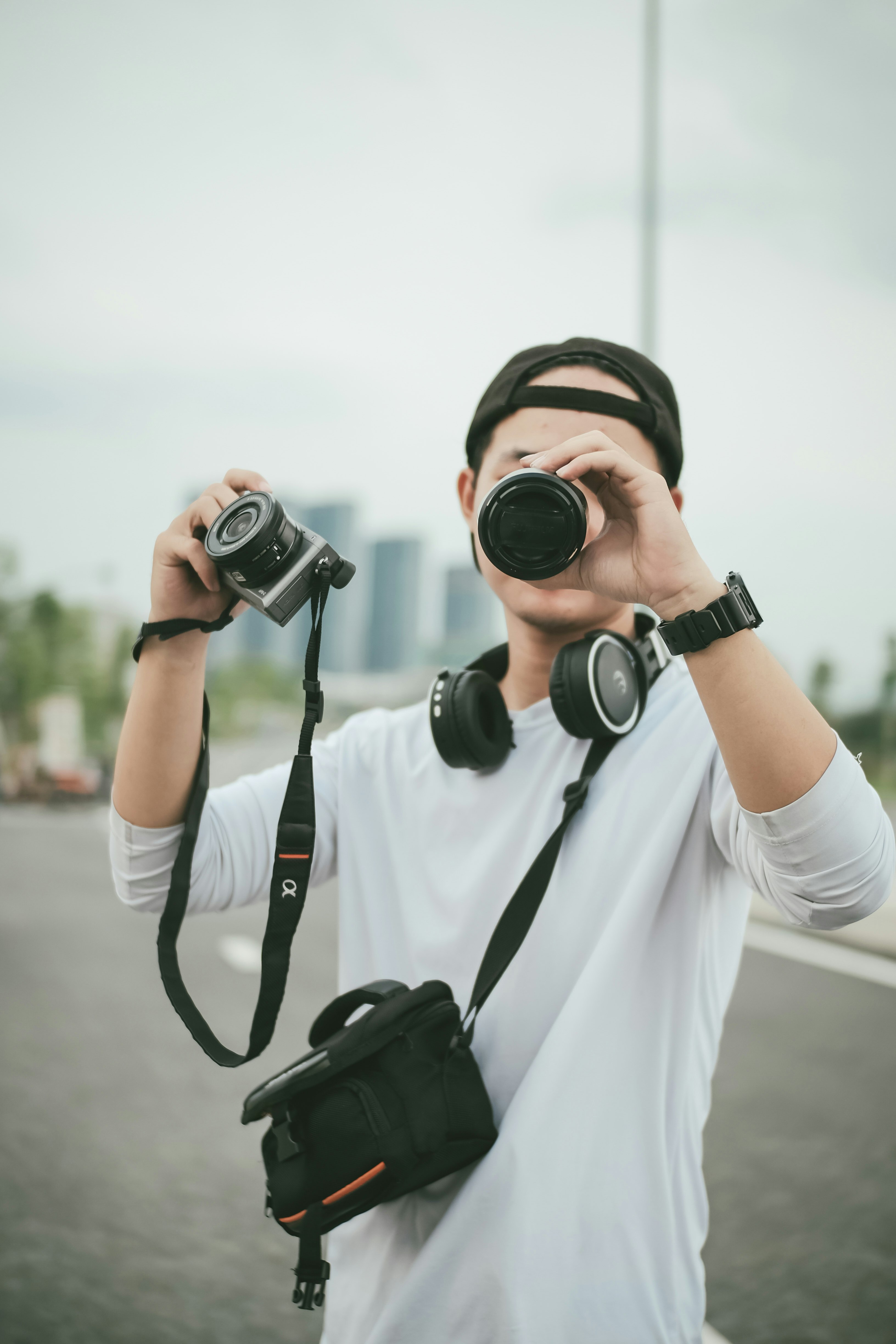 man in white shirt holding black dslr camera